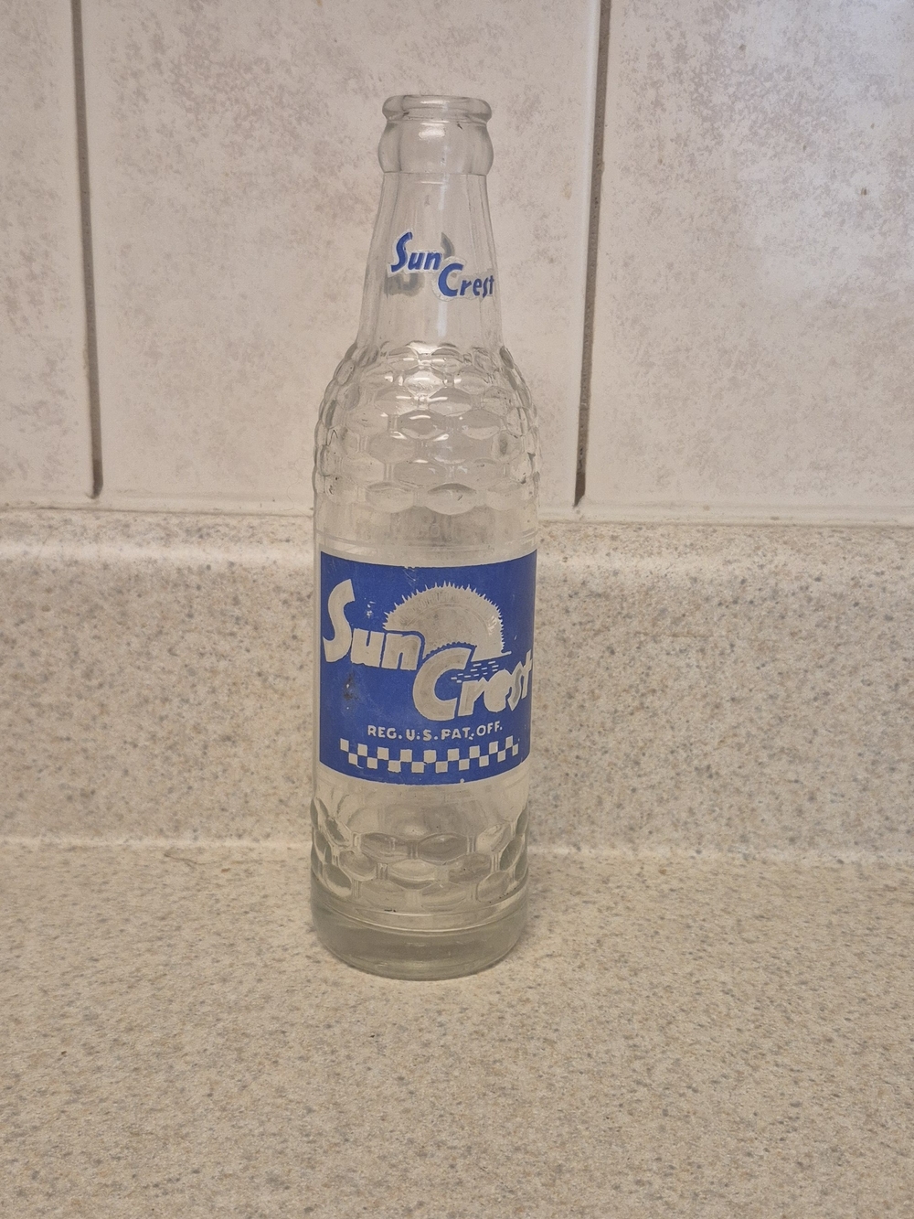 Crest Clear Glass Bottle with Bold Blue Sun Crest Label